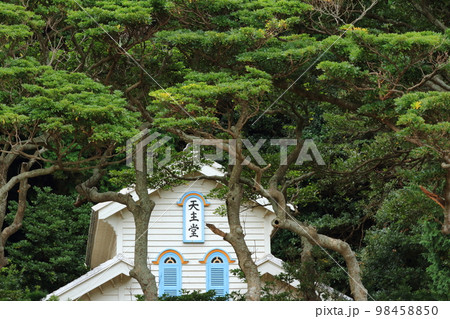 木々の間から望む世界文化遺産の奈留島の江上天主堂 98458850
