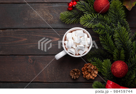 Red mug with hot chocolate on top of which pieces of marshmallows float, top view copy space 98459744