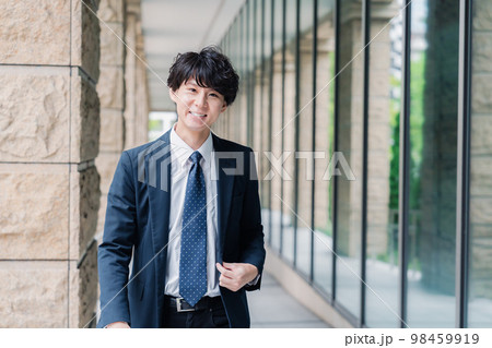 オフィスをさわやかに歩くビジネスマン オフィスをさわやかに歩くビジネスマン 98459919