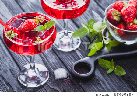 strawberry cocktail with ice and fresh mint on a black wooden table strawberry cocktail with ice and fresh mint on a black wooden table 98460387
