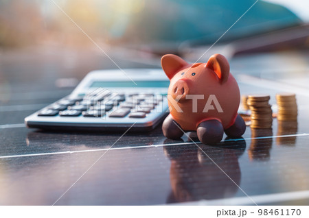 Piggybank on solar panel concept of money saved by using clean energy Piggybank on solar panel concept of money saved by using clean energy 98461170