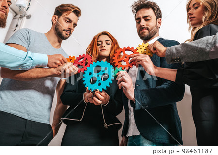 Teamwork of businesspeople work together and combine pieces of gears as partnership and integration 98461187