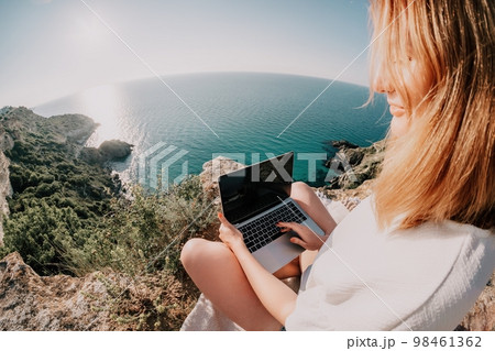 Woman sea laptop. Business woman working on laptop by sea at sunset. Close up on hands of pretty lady typing on computer outdoors summer day. Freelance, digital nomad, travel and holidays concept. 98461362