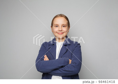 Little smiling cute pretty clever kid child girl 10 year old wearing blue school uniform standing  98461418