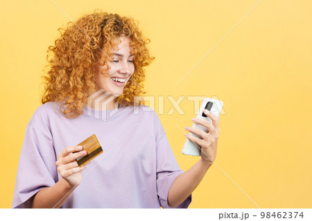 Woman using a card to shopping online with the mobile 98462374