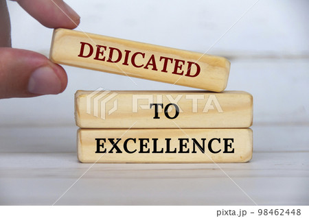 Dedicated to excellence text on wooden blocks with wooden cover background. Business motivation concept 98462448