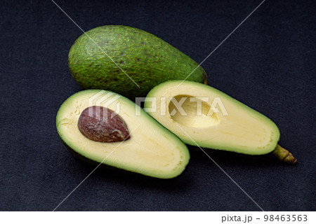 カットした国産アボカド、フェルテの実。黒色フェルト背景 カットした国産アボカド、フェルテの実。黒色フェルト背景 98463563