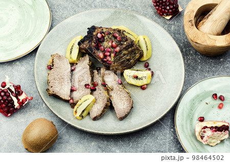 Beef meat baked with kiwi and pomegranate. Beef meat baked with kiwi and pomegranate. 98464502