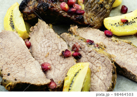 Veal meat baked with kiwi and pomegranate. Veal meat baked with kiwi and pomegranate. 98464503