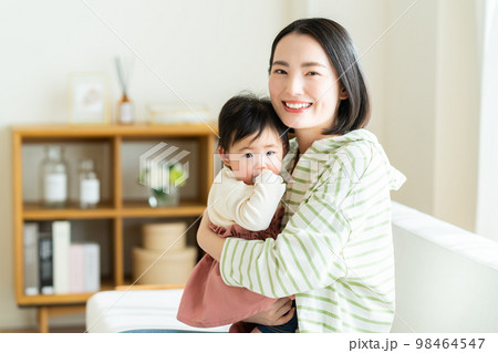 リビングでくつろぐ若い母子 98464547