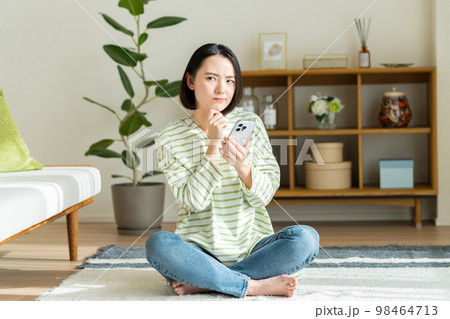 リビングでくつろぐ若い女性 リビングでくつろぐ若い女性 98464713