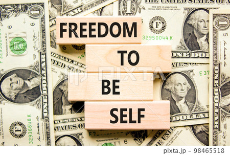 Freedom to be self symbol. Concept words Freedom to be self on wooden blocks on a beautiful background from dollar bills. Business, psychological freedom to be self concept. 98465518