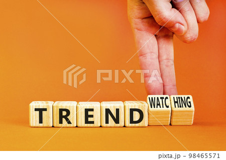 Trend or trendwatching symbol. Concept words Trend and trendwatching on wooden cubes. Businessman hand. Beautiful orange table orange background. Business trend or trendwatching concept. Copy space. 98465571