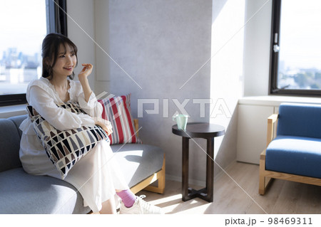 オフィスのソファでくつろぎながら会話する女性。 オフィスのソファでくつろぎながら会話する女性。 98469311