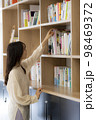 オフィスの書棚で本を探す若い女性 98469372