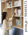 オフィスの書棚で本を探す若い女性 98469373