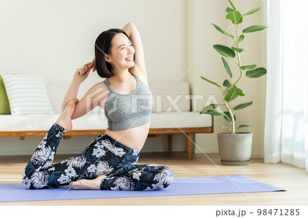 リビングでヨガをする若い 98471285