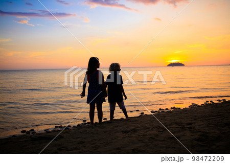 Child playing on ocean beach. Kid at sunset sea. 98472209