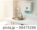 Modern hospital ward, hand washing sink, liquid soap disinfector automatic dispenser, paper towels. 98473266