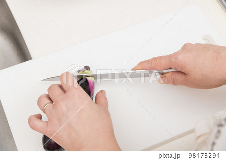 【茄子のヘタを三徳包丁で切る】 98473294