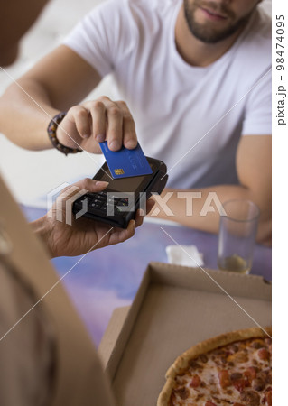 Male customer using credit card in cafe, paying for meal Male customer using credit card in cafe, paying for meal 98474095
