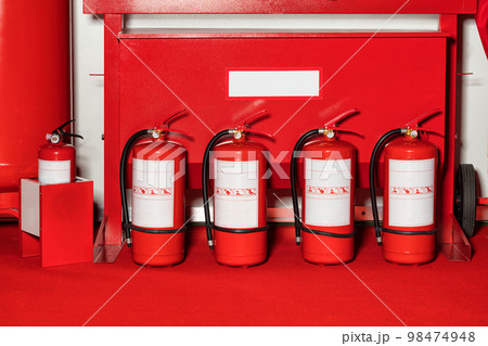Fire shield with fire extinguishers standing in a row. Fire shield with fire extinguishers standing in a row. 98474948