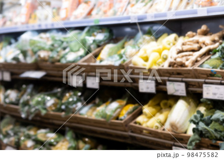 Defocused background with supermarket's shelf with wooden boxes of vegetables. Concept of selling eco-friendly food 98475582
