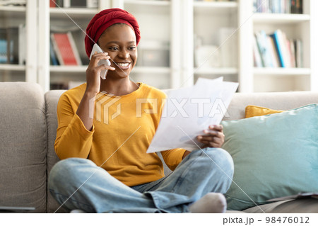 African american woman working from home, having phone conversation African american woman working from home, having phone conversation 98476012