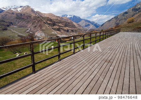Empty wooden terrace with Stepantsminda landscape on a background 98476648