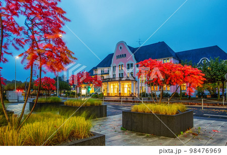 Garden in potted plants with autumn leaf color , red leaves, next to factory in Leverkusen and old building in distance Garden in potted plants with autumn leaf color , red leaves, next to factory in Leverkusen and old building in distance 98476969