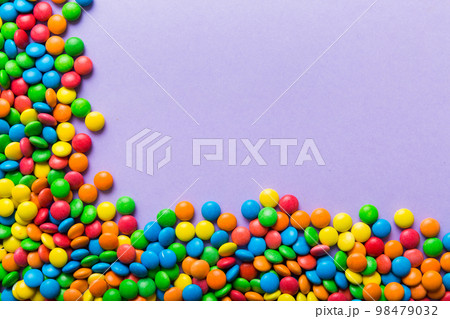 Mixed collection of colorful candy, on colored background. Flat lay, top view. frame of colorful chocolate coated candy Mixed collection of colorful candy, on colored background. Flat lay, top view. frame of colorful chocolate coated candy 98479032