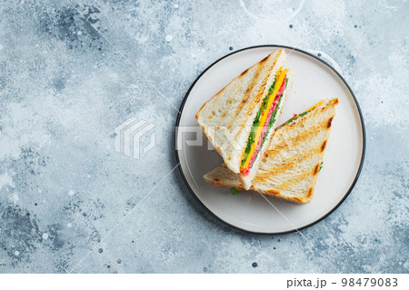 Two homemade sandwiches with sausage, cheese and arugula on a light concrete background 98479083