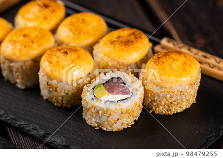 Sushi roll with tuna, avocado and tobiko caviar served on black board close-up - Japanese asian food 98479255