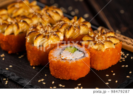 California sushi roll with crab, avocado and tobiko caviar served on black board close-up - Japanese food California sushi roll with crab, avocado and tobiko caviar served on black board close-up - Japanese food 98479287