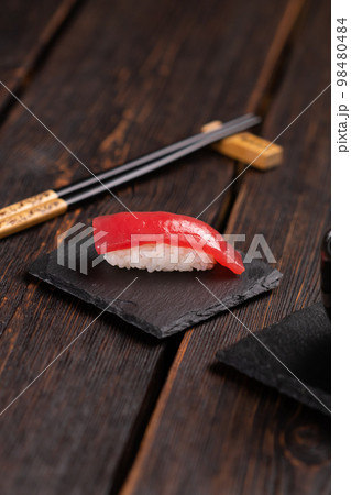 Delicious sushi maguro tuna. Nigiri with tuna on black and wooden background . Traditional Japanese cuisine Delicious sushi maguro tuna. Nigiri with tuna on black and wooden background . Traditional Japanese cuisine 98480484