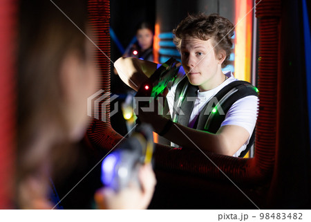 Portrait of man with laser gun having fun with family on laser tag arena Portrait of man with laser gun having fun with family on laser tag arena 98483482