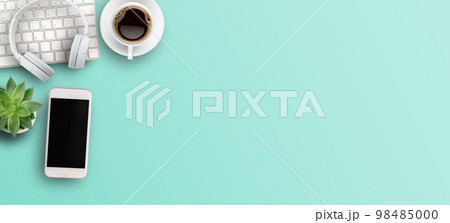 Top view with call center desktop,headset,smartphone and accessories on green background. Top view with call center desktop,headset,smartphone and accessories on green background. 98485000