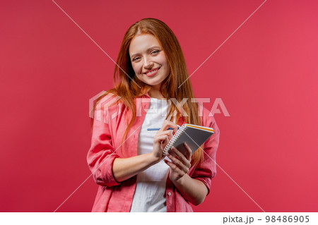 Young woman writing notes in planner with pen. Student girl thinking about future plans and to-do 98486905