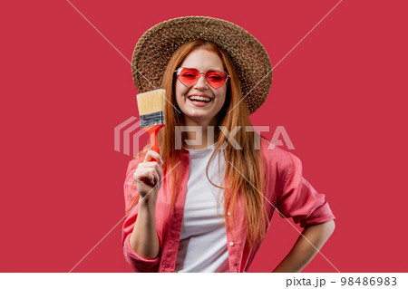 Young woman artist with brush on viva magenta or pink background. Creative person, fantasy, idea Young woman artist with brush on viva magenta or pink background. Creative person, fantasy, idea 98486983