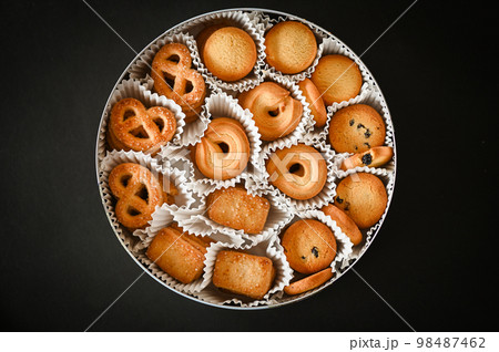 cookie box with danish butter cookies on black table background, top view cookie box with danish butter cookies on black table background, top view 98487462