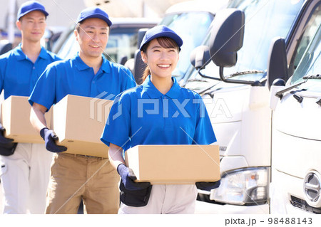 笑顔で荷物を運ぶユニフォーム姿の配達スタッフ　運送　物流　ビジネスイメージ 98488143