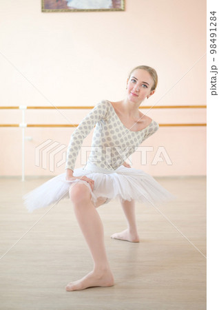 A very flexible ballerina in a tutu stands in a plie in a class with ballet machines. Incredibly Plastic Dancer. A very flexible ballerina in a tutu stands in a plie in a class with ballet machines. Incredibly Plastic Dancer. 98491284