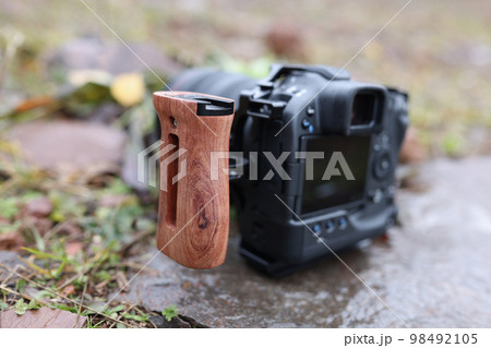 Photo camera with side handle outdoors close-up. Photo camera with side handle outdoors close-up. 98492105