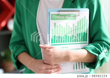 Female financial manager holding clipboard with attached documents. 98492154