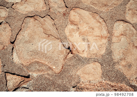 A masonry wall of stones or blocks, abstract rocks texture, mineral pavement, light brick wallpaper, rough masonry. Selective focus. 98492708