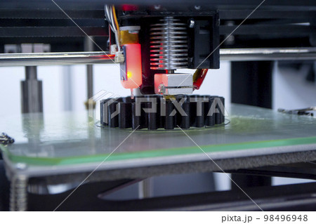 3d printer printing a model close-up. The process of printing a model on a 3D printer made of orange plastic. 3D printer working close up 98496948