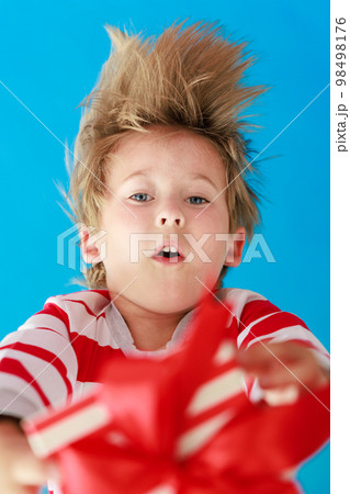 Surprised child holding Christmas gift 98498176