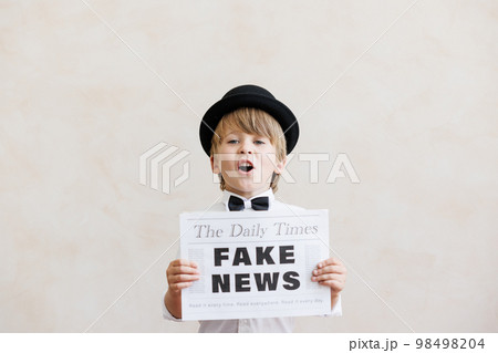 Newsboy shouting against grunge wall background. Boy selling fake news Newsboy shouting against grunge wall background. Boy selling fake news 98498204