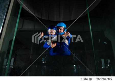 A man teaches a boy to fly in a wind tunnel. Lack of gravity. 98498765
