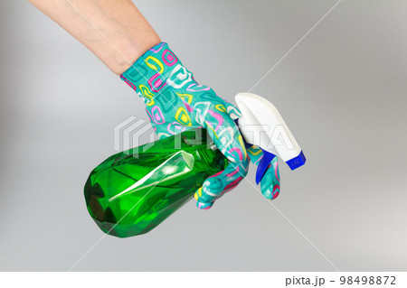 Woman's hand with a pressure sprayer on gray background. 98498872